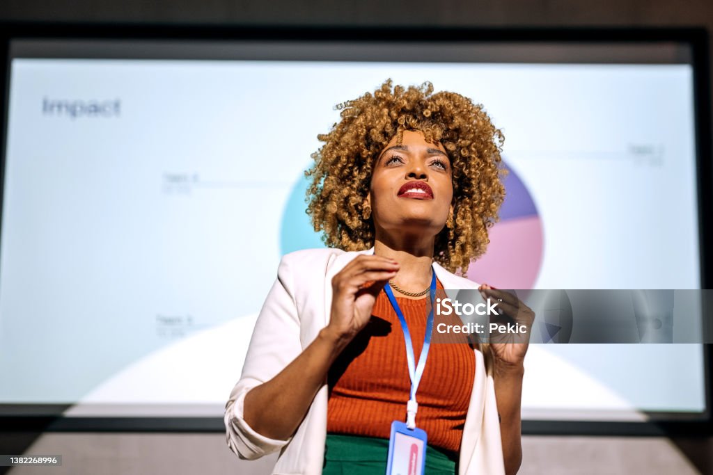 Casually clothed hipster woman holding a speech on a conference Casually clothed hipster woman holding a speech on a business conference Presentation - Speech Stock Photo