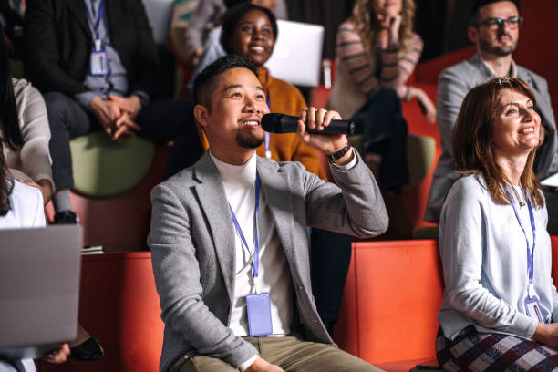 istock Well dressed young man asking presenter a question while attending business conference 1382270426