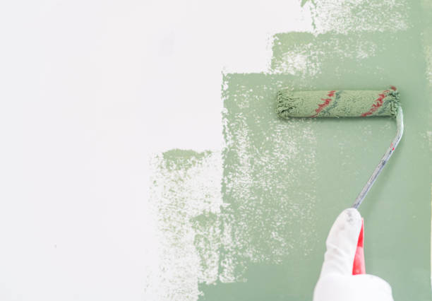 Mature man painting wall in apartment