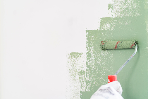 Mature man painting wall in apartment
