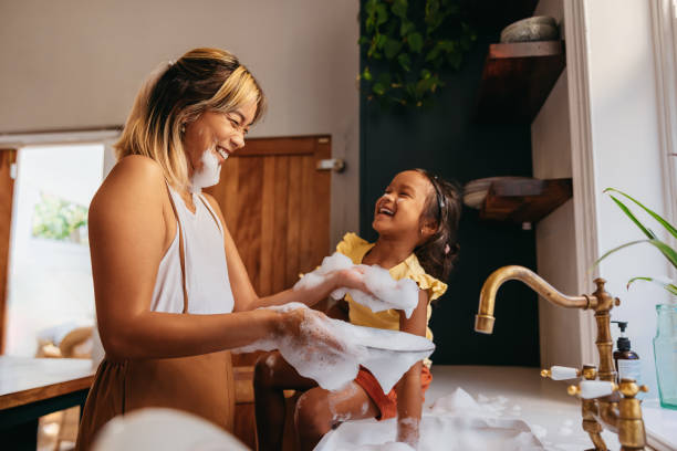 istock Happy mother and daughter having fun with soap bubbles 1382272090