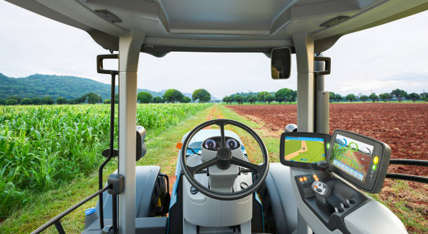 Autonomous tractor working in corn field, Future technology with smart agriculture farming concept stock photo