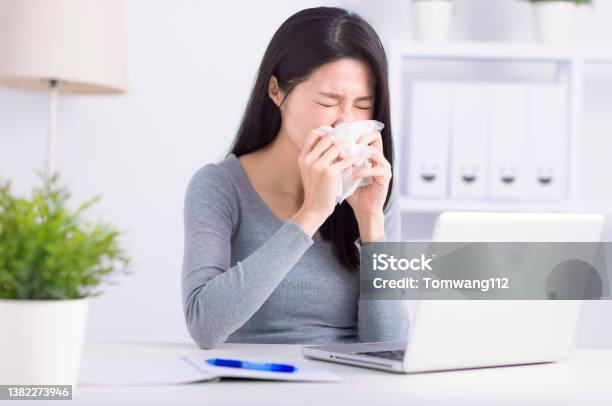Stressed Young Woman Sneezing And Working At Home Office Stock Photo - Download Image Now