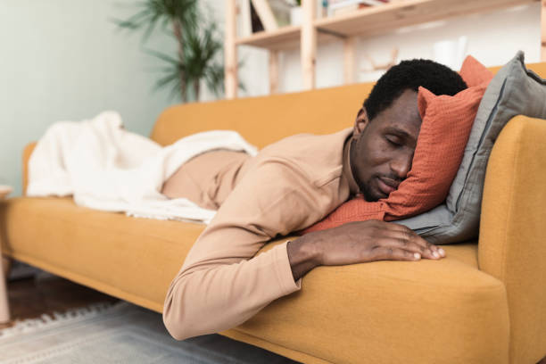 istock Young African man with a sore throat napping on the couch 1382274610