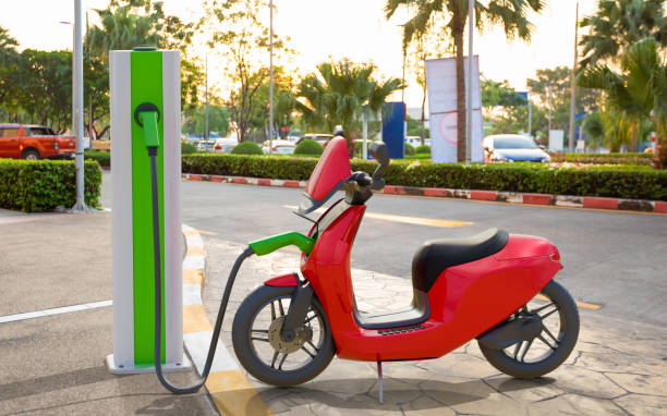 an electric scooter charging at power station - electric motor fotos imagens e fotografias de stock