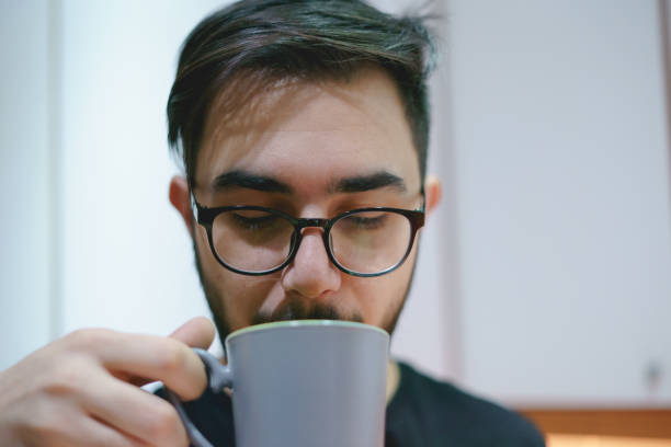 taking a break, placing the spectacles on the bar table by an espresso cup and a laptop