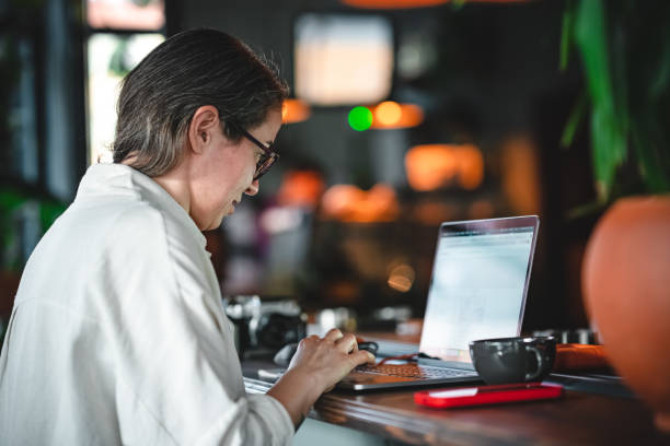 istock Woman using laptop at coffee shop 1382275535