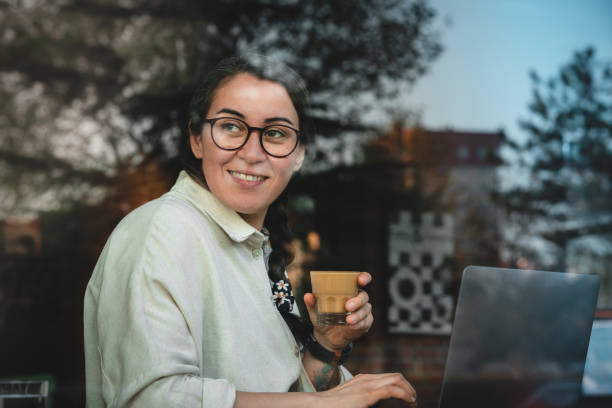 Woman working on laptop at coffee stock photo