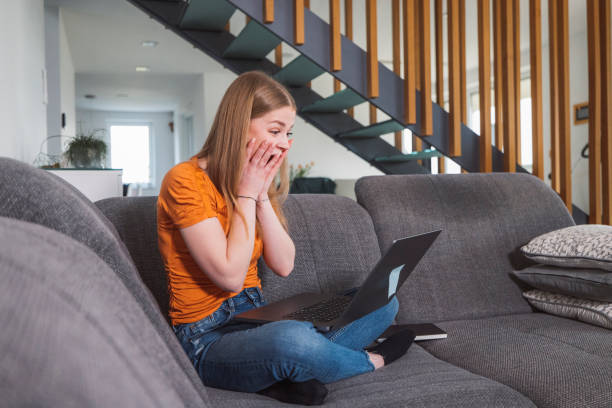 istock Very happy young woman smiling while looking at her laptop 1382276716