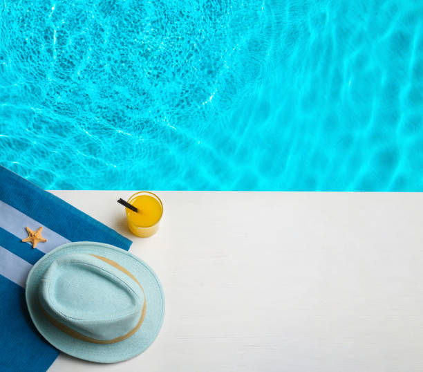 istock Beach accessories on white wooden deck near swimming pool, flat lay. Space for text 1382277162