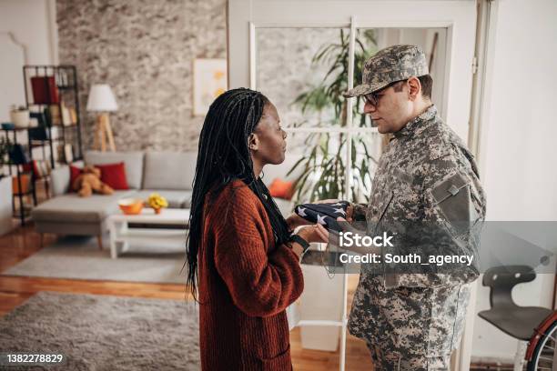 Soldier Bringing Folded American Flag To Widow At Home To Say Her That She Has Lost Her Husband In The Army War Stock Photo - Download Image Now