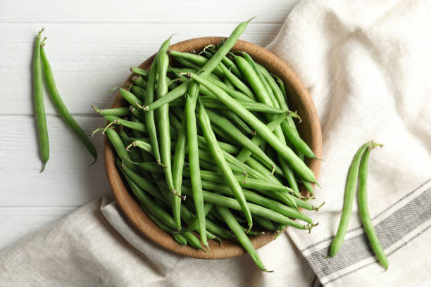 istock Fresh green beans on white wooden table, flat lay 1382288802