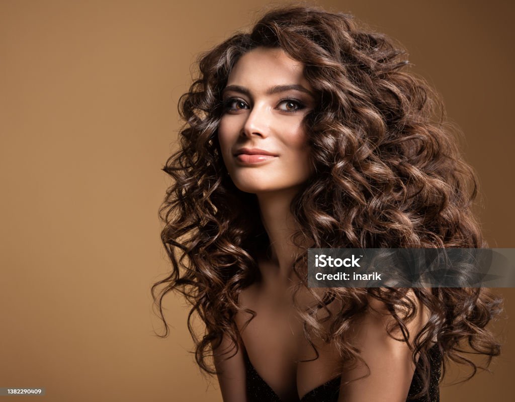 Curly Hair Model Woman Wavy Long Hairstyle Brunette Fashion Girl With  Volume Hairdo And Natural Make Up Over Beige Background Stock Photo -  Download Image Now - iStock