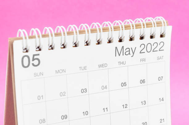 May text displayed on a wooden block against a wood background in close-up with Copy Space.