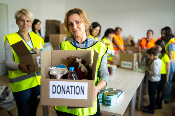 frauen engagieren sich ehrenamtlich in der lebensmittelaktion für arme menschen - child toy giving organization stock-fotos und bilder