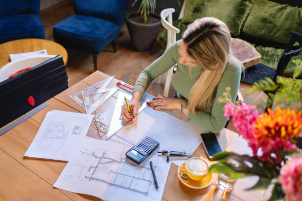 At the modern coffee shop, focused Caucasian female architect working stock photo