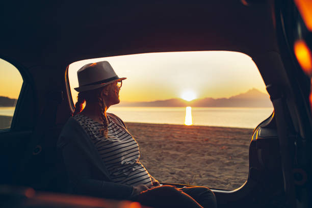 istock Pregnant woman watching the sunset on a beach 1382294701