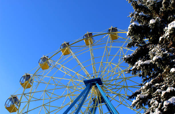 Ferris wheel, trees along the track through the drifts of snow