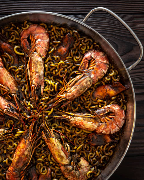 receta de paella de fidegua en una sartén con calamares de camarón y mariscos - fideua fotografías e imágenes de stock