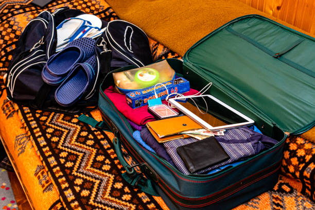istock Open suitcase with things. Things collected for a vacation trip. 1382340431