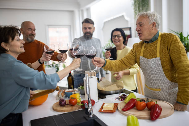 istock Serene Caucasian senior friends toasting with red wine while making lunch in the kitchen 1382344764