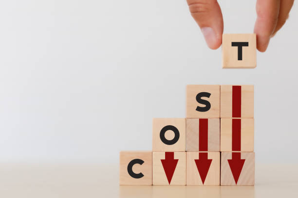 istock Cost reduction concept. Lean manufacturing management. Decreasing company expense to maximize profits. Hand puts wooden cube with text âcostâ with red down arrows .Business survival and improvement. 1382345885