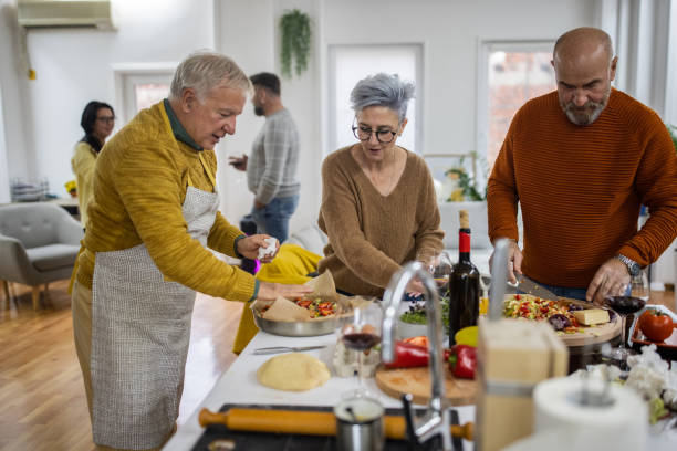 istock Senior friends having fun while making vegan pizza in the kitchen 1382346468