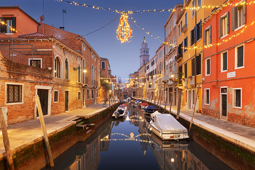 Venice, Italy cityscape over canals at twilight with Christmas lights.