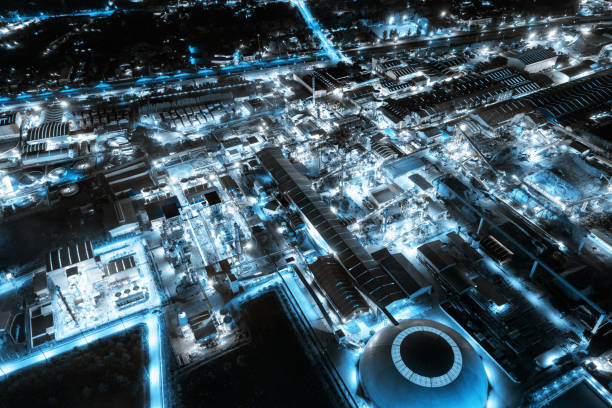 fabbrica industriale a luce blu con raffineria chimica e materiale da costruzione che brilla di luce di notte - oil distribution foto e immagini stock