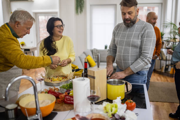 istock Cheerful senior and mature friends having fun while making homemade pizza 1382355152