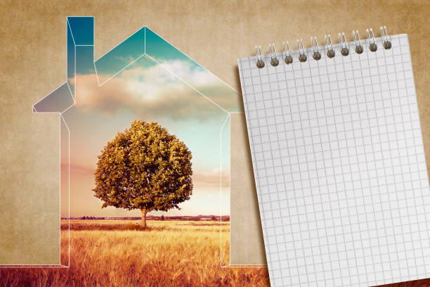 istock Little home silhouette, rural scene with a lone tree in a field, block notes with copy space 1382357402