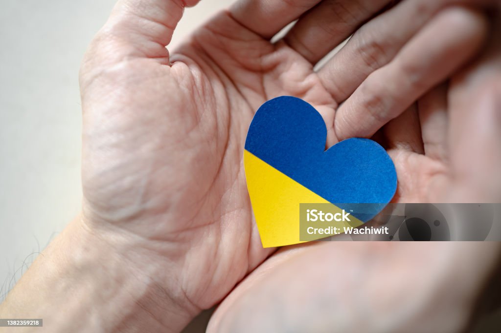 Ukraine flag color heart in hands Stand with Ukraine Stock Photo