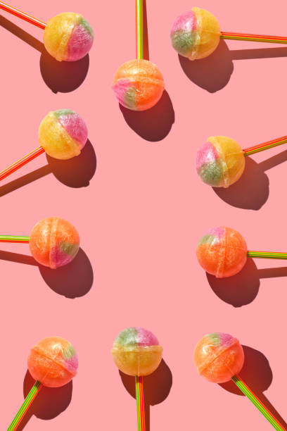 カラフルなロリポップセット。明るいピンクの背景にスティックにキャラメルで作られたパターン。 クリエイティブパターン。 ロリポップチャプチャプの多く。 - lollipop sucking candy sweet food ストックフォトと画像