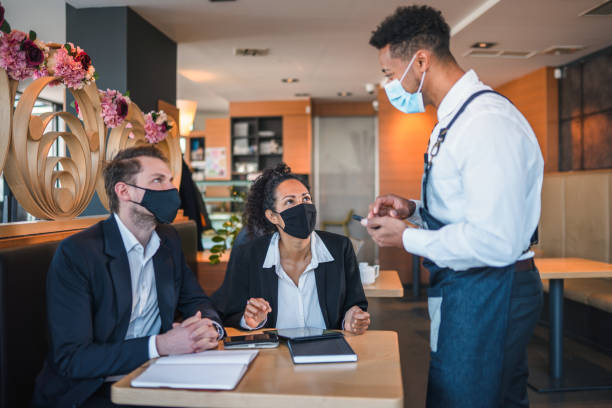 istock Mixed Race Waiter Taking an Order Form Diverse Business People 1382365415