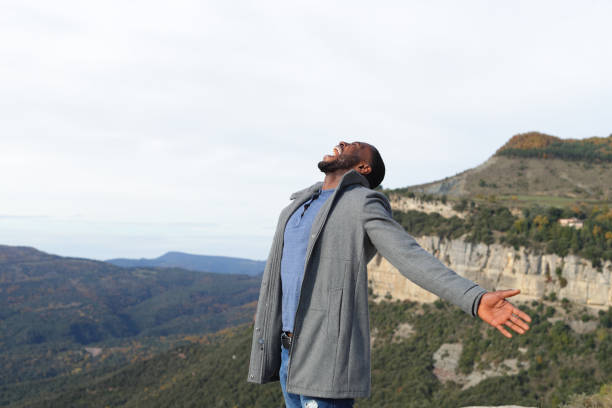 istock Euphoric man with black skin outstretching arms in winter 1382367649