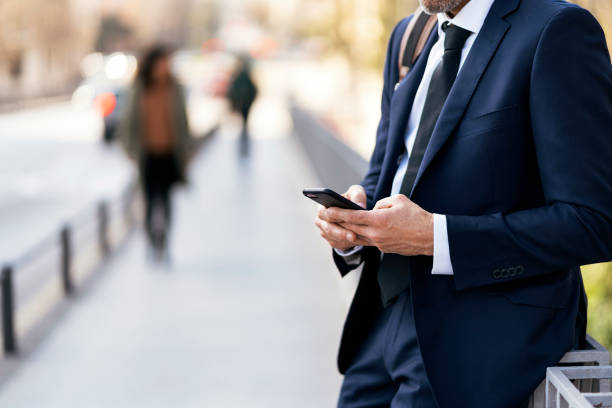 istock Crop businessman using smartphone on street 1382371277
