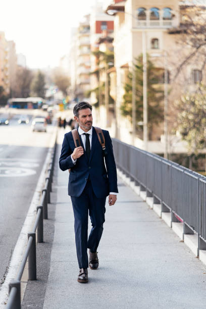 istock Handsome businessman walking in city 1382371300