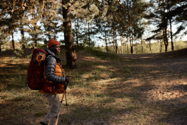 facet uprawiający nordic walking w dziewiczej przyrodzie, pobyt na skrzyżowaniu, wybór właściwego kierunku, poszukiwanie kempingu. samotnie na świeżym powietrzu na wsi. aktywny tryb życia, podróż i koncepcja natury. miejsce kopiowania - tree skill nature horizontal zdjęcia i obrazy z banku zdjęć