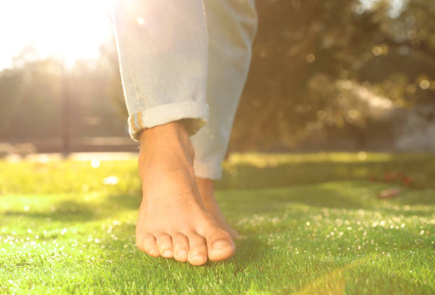 istock Man walking barefoot on fresh green grass, closeup 1382374841