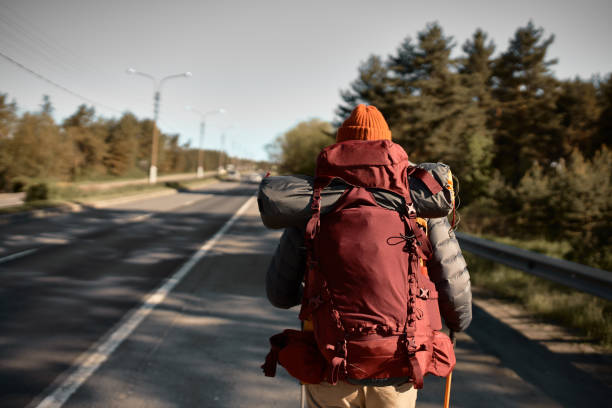 istock Young man explorer wander on highway, create own route or lost direction. Guy with backpack for camping in mountains. All by yourself, open new place, travelling in nature, hiking concept. Copy space 1382375613