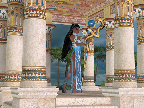 An Egyptian queen stand among columns at the entrance to a temple at a desert oasis.
