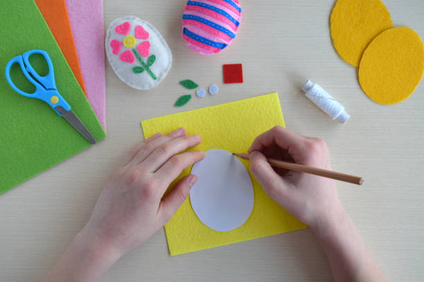 istock Making handmade easter eggs from felt with your own hands. Childrens DIY concept. Easter decoration 1382381137