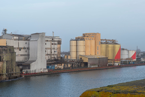 Grain silo and industrial building on the quay of a harbour in Saint Nazaire, France, with boats