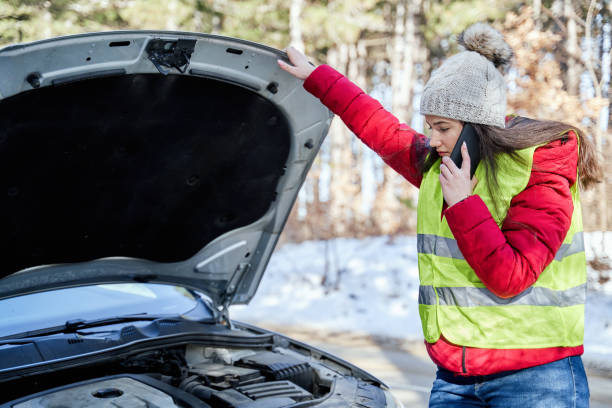 istock Young woman with a broken car calling roadside assistance 1382384346