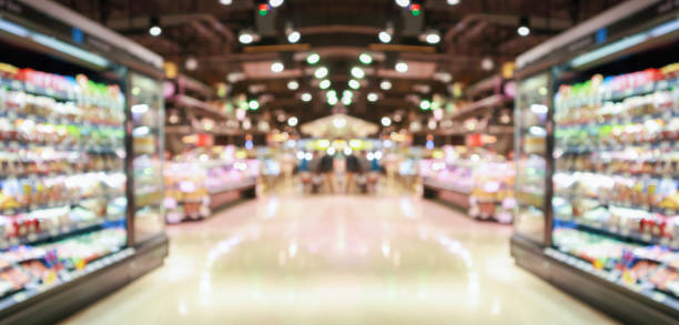 supermarket grocery store aisle and shelves blurred background - mercearia imagens e fotografias de stock