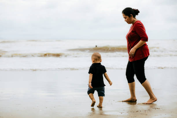 istock grandmother watching baby when walking on the beach 1382391499