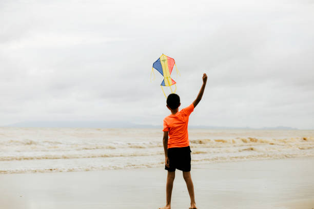 istock asian kid running with kite on beach 1382394250