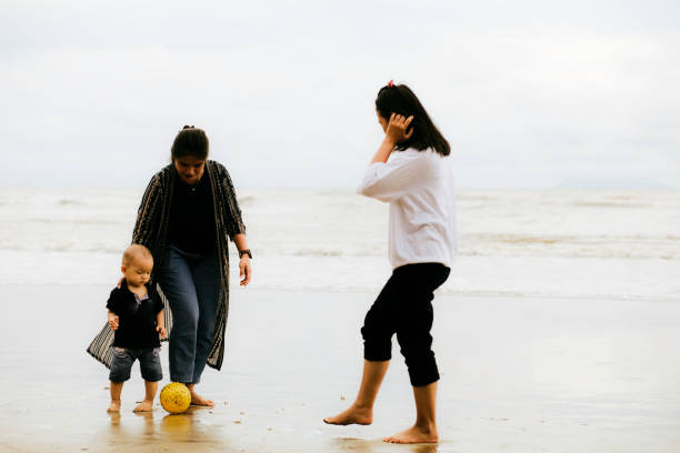 young asian woman playing on the beach with baby boy young asian woman playing on the beach with baby boy malay couple full body stock pictures, royalty-free photos & images
