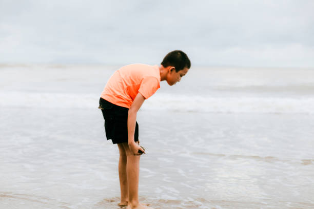 istock asian kid playing on the beach 1382397655