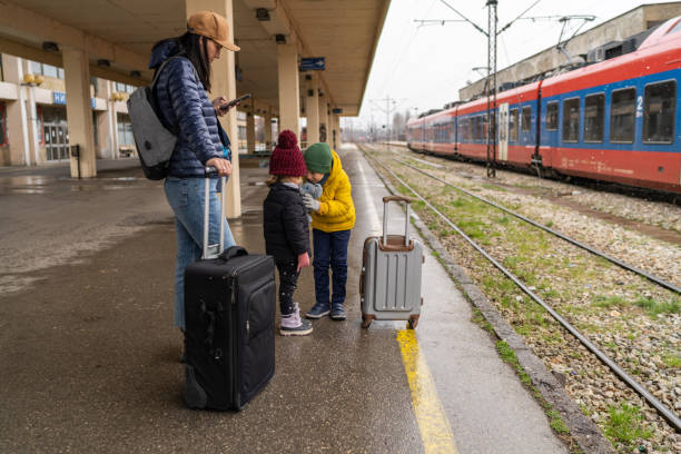 istock Single mother and two small children waiting for a train 1382397835